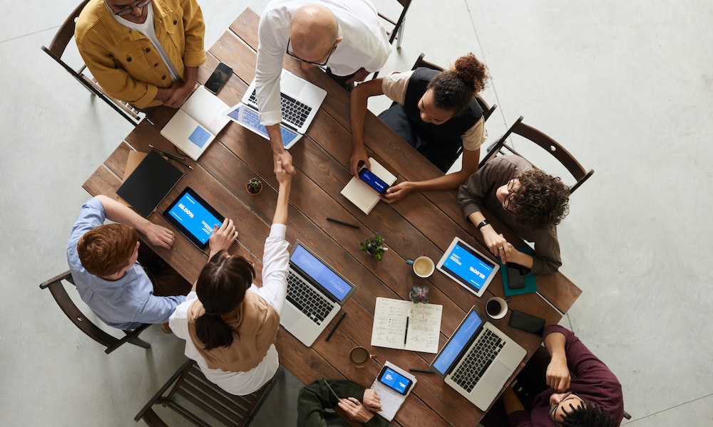 Team signs new contract to hire position and meets together at table