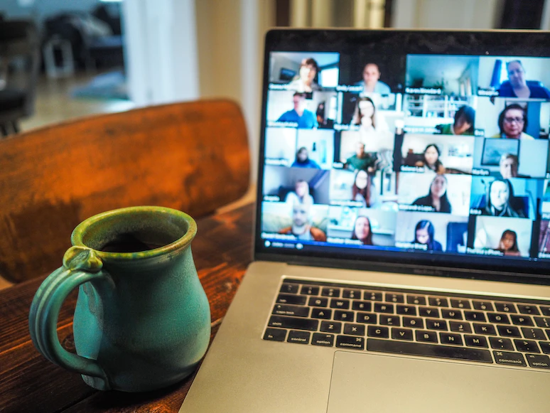 coffee cup next to virtual meeting