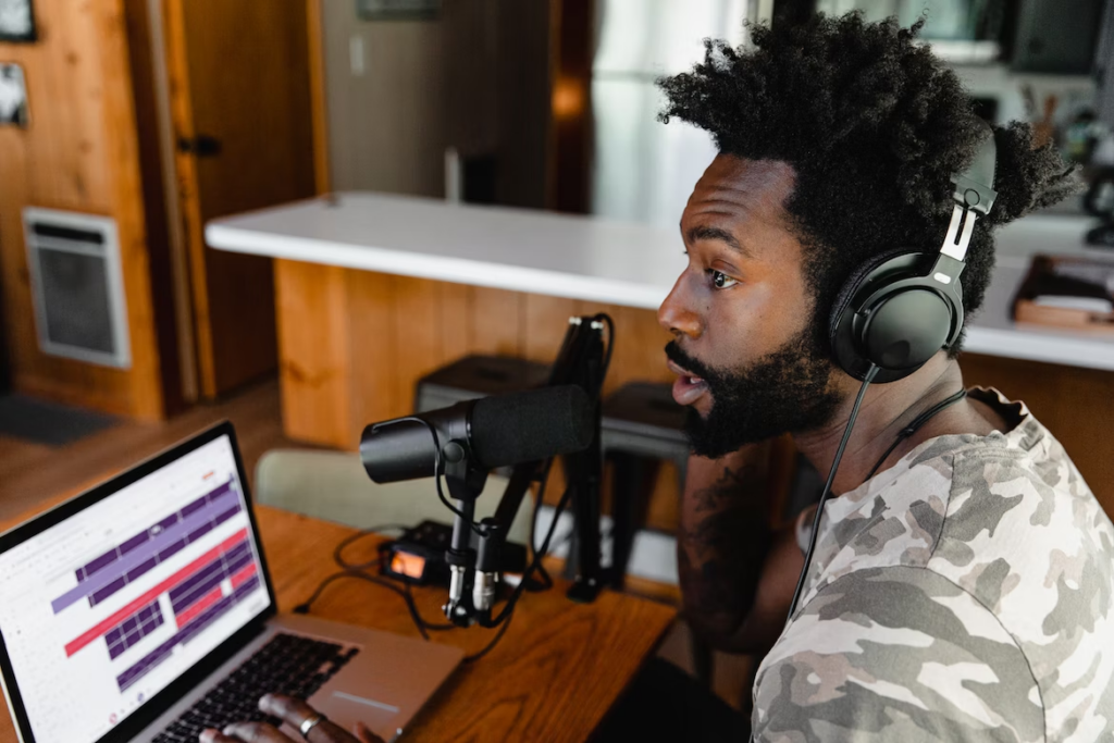 a man recording a podcast from his home with editing computer in front of him